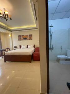 een slaapkamer met een bed en een badkamer met een douche bij Đà Lạt Hotel 