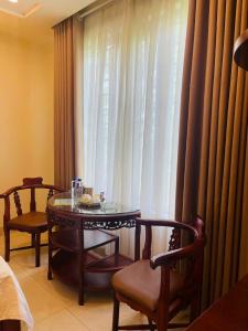 een kamer met een tafel en stoelen en een raam bij Đà Lạt Hotel 