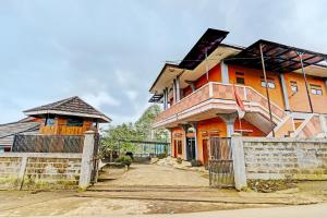 an orange house with a fence in front of it at OYO 92217 Artana Bed and Breakfast in Pengalengan