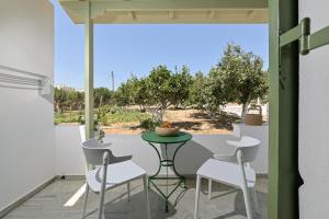 eine Terrasse mit einem Tisch und Stühlen auf dem Balkon in der Unterkunft Naxian Garden of Senses in Agia Anna