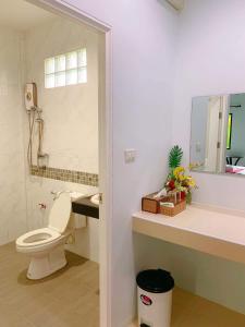 y baño con aseo, lavabo y espejo. en พร้อมหทัย รีสอร์ท Promhathai Resort, en Ban Khlong Toei (1)