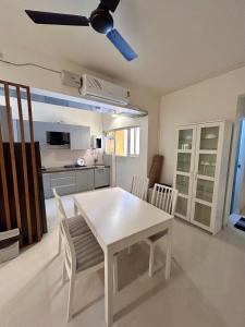 einen weißen Esstisch und Stühle in der Küche in der Unterkunft Good Stay Premium 2 BHK Apartment 103 in Vasco Da Gama