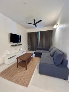 a living room with a blue couch and a tv at Good Stay Premium 2 BHK Apartment 103 in Vasco Da Gama