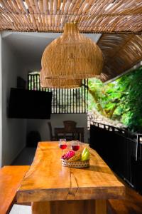a table with two glasses of wine and a basket of fruit at Bali Invest Living in Canggu