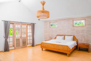- une chambre avec un lit et une grande fenêtre dans l'établissement Bali Invest Living, à Canggu