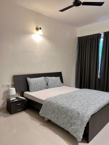 Good Stay Premium 2 BHK Apartment 103 في فاسكو دا غاما: غرفة نوم بسرير ومروحة سقف