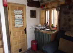 Habitación con cocina, puerta y lavabo. en Casita con encanto tranquilidad VILLAVIEJA DEL LOZOYA Wi-Fi No fumador EN SIERRA DE MADRID Y A 40 M DE CAPITAL en Villavieja del Lozoya