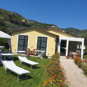 レヴァントにあるAgriturismo La Collina Verdeの芝生の椅子2脚と建物