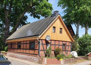 una pequeña casa con paneles solares en el techo en Kleines Haus 110m2 in Lilienthal mit Garten, Wifi und 3 Schlafzimmern, en Lilienthal