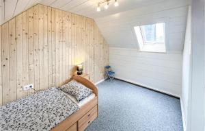 1 dormitorio con 1 cama con pared de madera en Kleines Haus 110m2 in Lilienthal mit Garten, Wifi und 3 Schlafzimmern, en Lilienthal