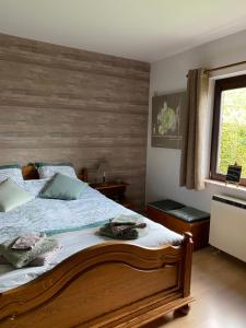 um quarto com uma cama e uma parede de madeira em Le Logis du Plateau em Herve