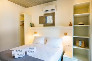 1 dormitorio con cama blanca y almohadas blancas en Flaros Village en Kamarai