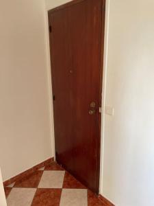 een hal met een bruine deur en een tegelvloer bij Studio Gentilly/Paris 14 in Gentilly