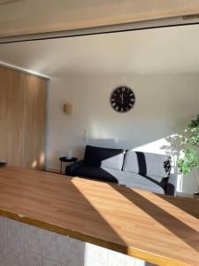 een woonkamer met een bank en een klok aan de muur bij Studio Gentilly/Paris 14 in Gentilly