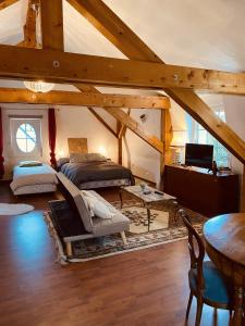 a attic room with two beds and a table at LA MARIEFACTURE - Comme sous les toits in Saint-Avold
