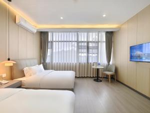 a hotel room with two beds and a flat screen tv at Airport Dream B&B - Tianfu International Airport Branch in Jianyang