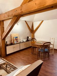 a room with a wooden table and a dining room at LA MARIEFACTURE - Comme sous les toits in Saint-Avold