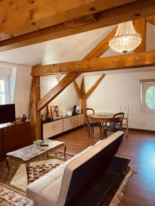 a living room with a table and a couch at LA MARIEFACTURE - Comme sous les toits in Saint-Avold