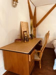 a wooden desk in a room with a chair at LA MARIEFACTURE - Comme sous les toits in Saint-Avold