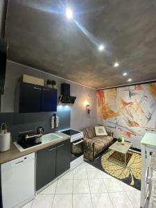 a kitchen and a living room with a couch at LA MARIEFACTURE - Comme c'est chic in Saint-Avold