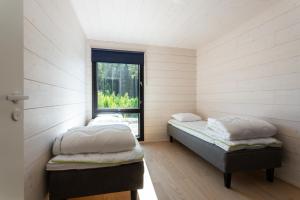 two beds in a room with a window at Himoskuutio 9, erillistalo, ulkoporeallas in Jämsä
