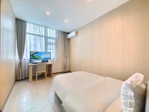 JianyangにあるAirport Dream B&B - Tianfu International Airport Branchのベッド、デスク、テレビが備わるホテルルームです。
