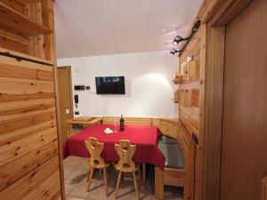 una sala da pranzo con tavolo e sedie rossi di Appartamento Santa Caterina a Santa Caterina Valfurva