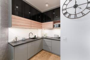 a kitchen with a large clock on the wall at Apartament Marengo Ku Morzu by HolidaySun in Sianozety