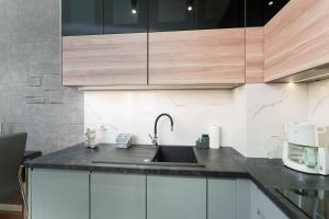 a kitchen with a sink and wooden cabinets at Apartament Marengo Ku Morzu by HolidaySun in Sianozety