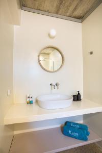 y baño con lavabo blanco y espejo. en Flaros Village en Kamarai