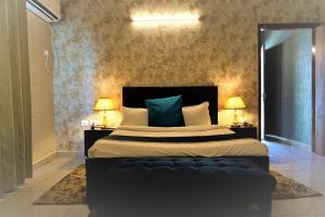 a bedroom with a large bed with two lamps on tables at Shivjot Farm & Resort Panchkula in Panchkula