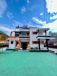 a building with a green lawn in front of it at Villa Copenhagen Bukittinggi in Bukittinggi