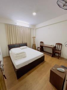 een slaapkamer met een bed, een bureau en een tafel bij Hotel Bihani in Dhulikhel