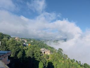 een stad bovenop een heuvel met wolken bij Hotel Bihani in Dhulikhel