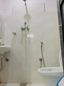 een witte badkamer met een douche en een toilet bij Hotel Bihani in Dhulikhel