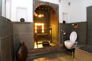 a bathroom with a toilet and a bowl in it at Madri Haveli in Udaipur