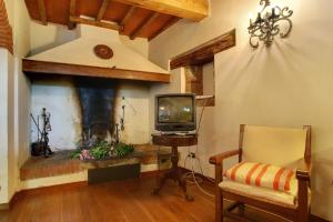 un soggiorno con TV e camino di Villa Perla - Homelike Villas a Reggello