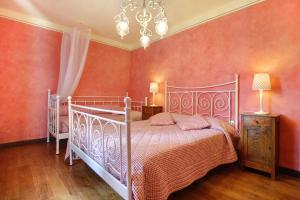 a bedroom with a bed with pink walls and a chandelier at Villa Perla - Homelike Villas in Reggello +12 photos