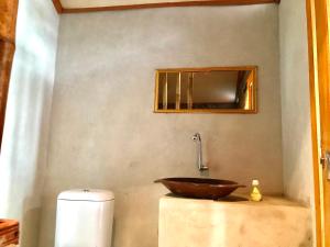a bathroom with a wooden bowl sink on a counter at Muni's Terrace Bungalow in Kotaraja