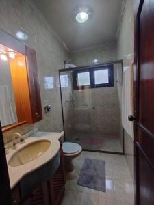 uma casa de banho com um chuveiro, um lavatório e um WC. em Sítio na Praia da Itapeva em Torres