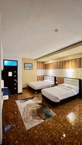 een grote slaapkamer met 2 bedden en een televisie bij Villa Copenhagen Bukittinggi in Bukittinggi