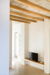 una sala de estar con paredes blancas y techos de madera. en Flaros Village en Kamarai