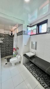 een witte badkamer met een toilet en een wastafel bij Villa Copenhagen Bukittinggi in Bukittinggi
