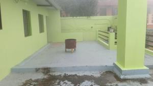 une chambre vide avec une chaise dans une maison blanche dans l'établissement Green Star Bungalow, à Kodaikānāl