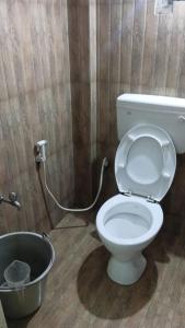 a bathroom with a toilet with a hose at Green Star Bungalow in Kodaikānāl