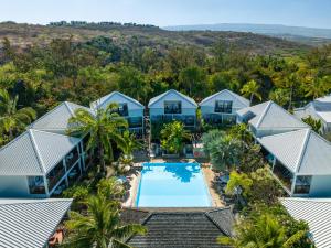 uma vista aérea de um resort com uma piscina e palmeiras em Hôtel Les Créoles em Saint-Gilles-les-Bains