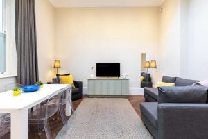 a living room with a couch and a tv at 2-BR apartment for 6 in Covent Garden with ac in London