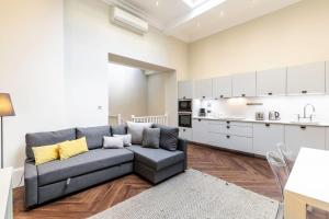 ein Wohnzimmer mit einem Sofa und einer Küche in der Unterkunft 2-BR apartment for 6 in Covent Garden with ac in London