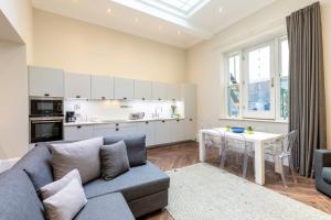 ein Wohnzimmer mit einem Sofa und einem Tisch sowie eine Küche in der Unterkunft 2-BR apartment for 6 in Covent Garden with ac in London