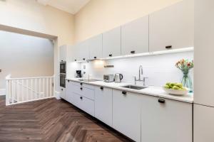 una cucina con mobili bianchi e un lavandino di 2-BR apartment for 6 in Covent Garden with ac a Londra Altre 15 foto